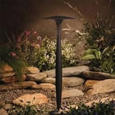 A tall LED light fixture overlooking a garden