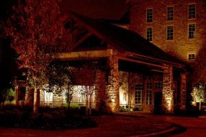 Lights shine up the stone walls of an office building