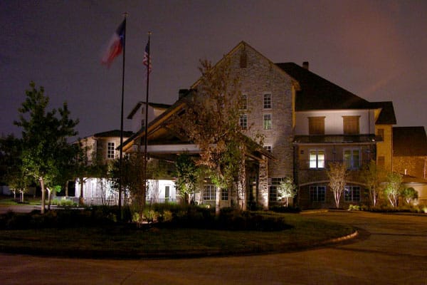 A commercial building flies the Texas and American flags in the evening