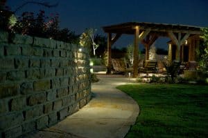 A pathway leading to a pergola is illuminated by LED lighting
