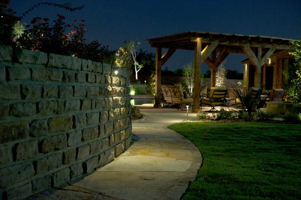 A pathway leading to a pergola is illuminated by LED lighting