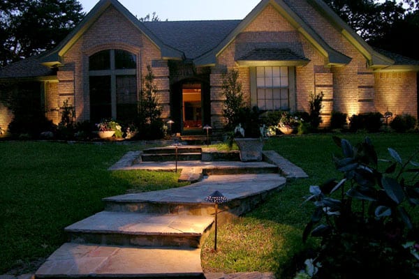 Sidewalk lit up with pathway lights leading up to home