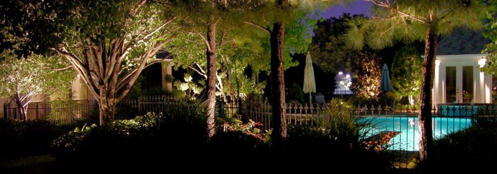 Iron fence surrounding pool with LED security lighting at night